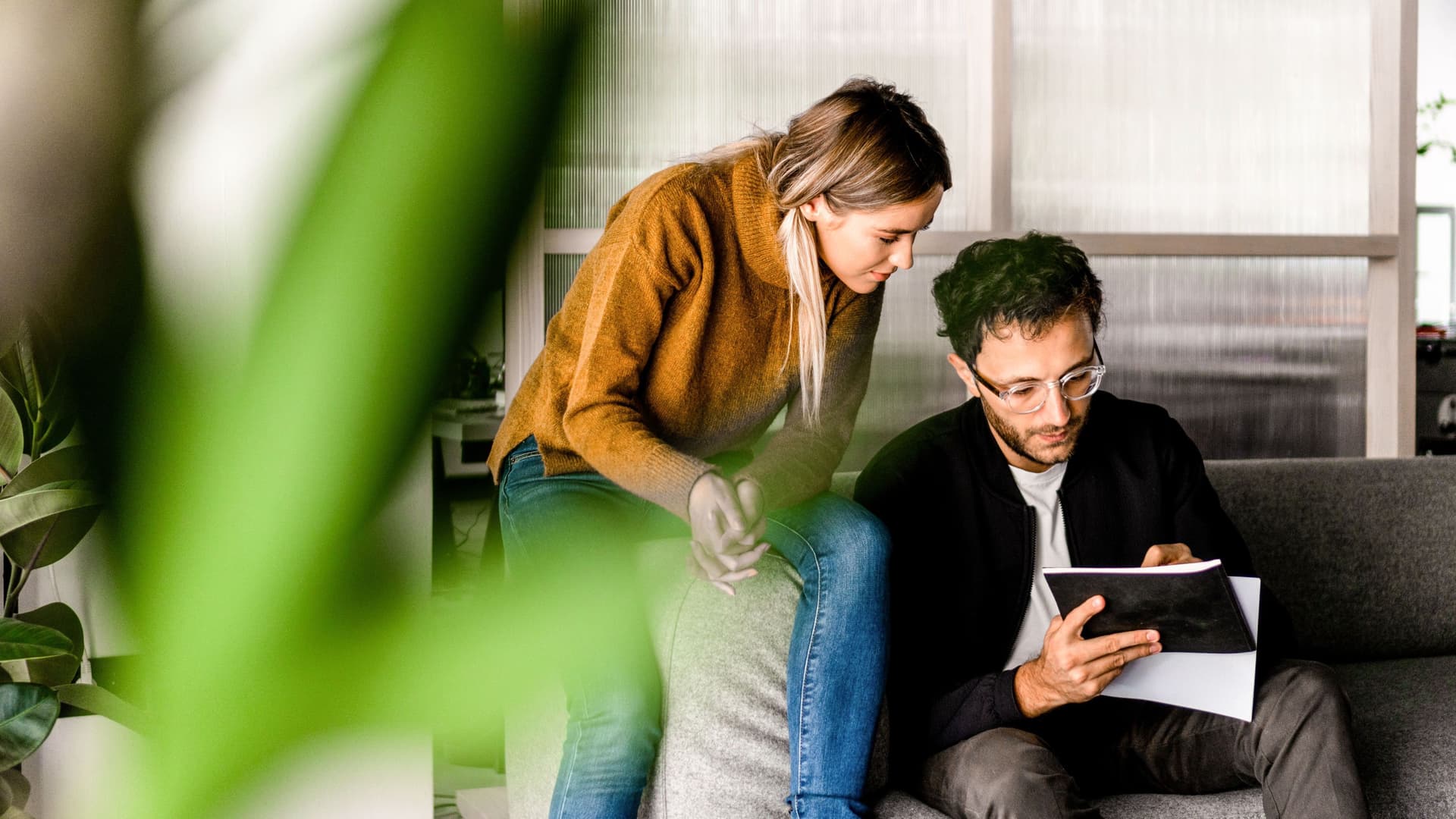 Junge Frau und Junger Mann planen auf der Couch