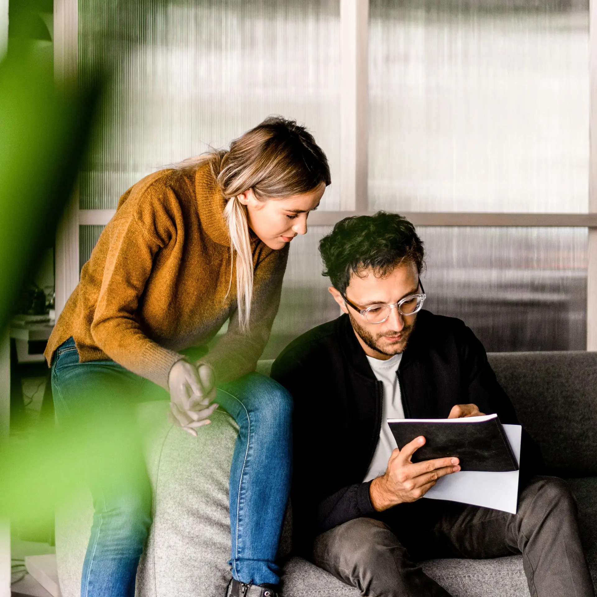 Junge Frau und Junger Mann planen auf der Couch