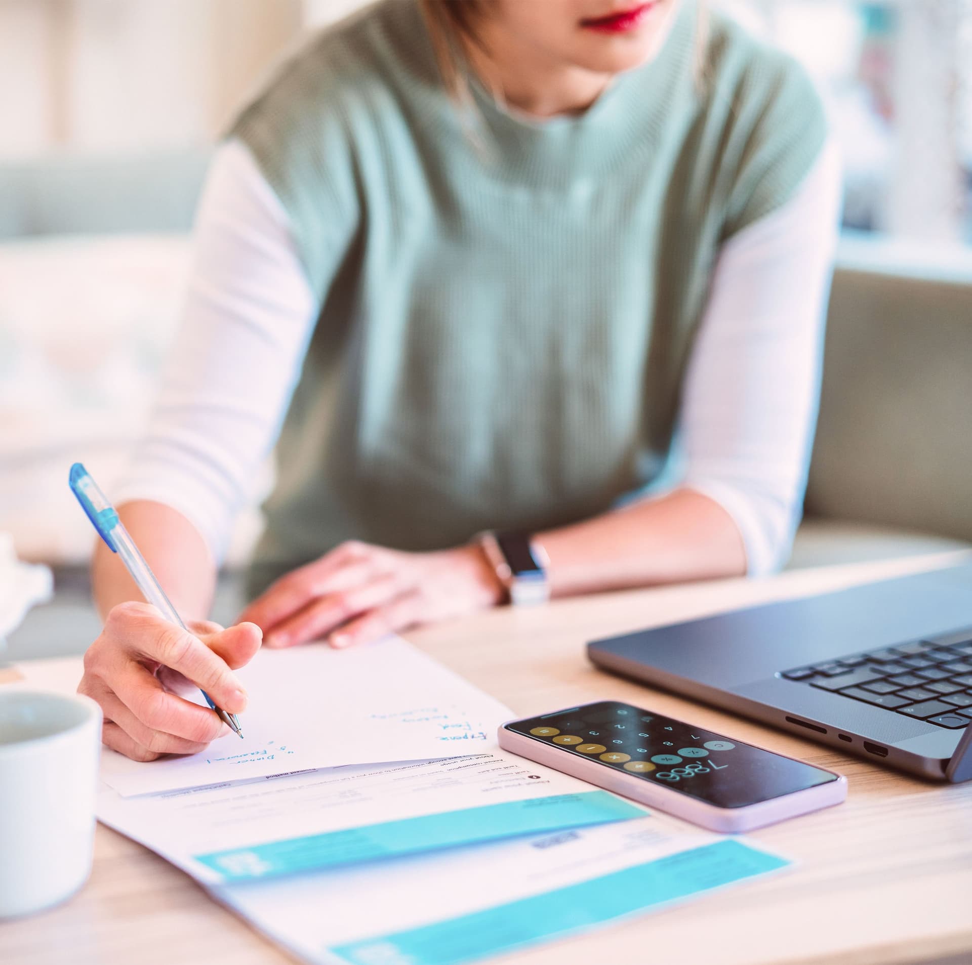 Junge Frau verwaltet Hausfinanzierung per Laptop und Smartphone