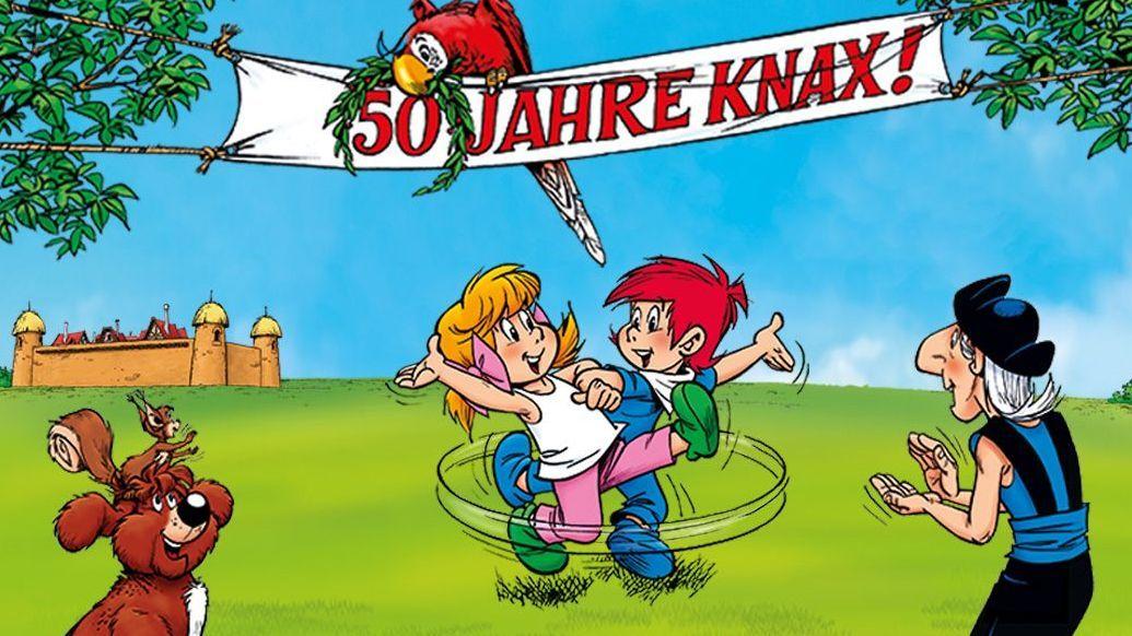 Knax-Charaktere feiern. Über ihnen hängt ein Banner mit der Aufschrift "50 Jahre Knax".