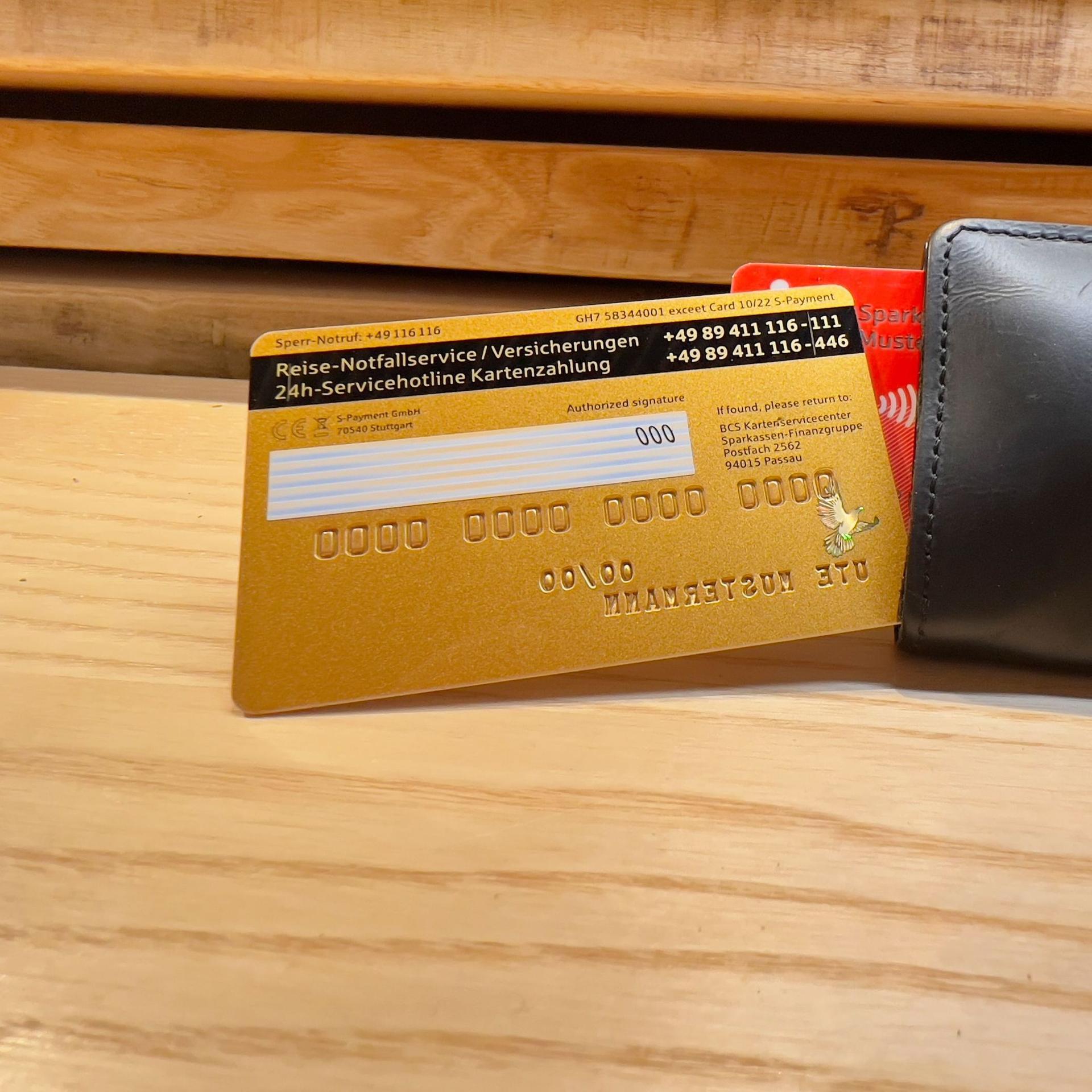 Eine goldene Kreditkarte liegt auf einem Geldbeutel. Die Prüfziffer ist sichtbar.