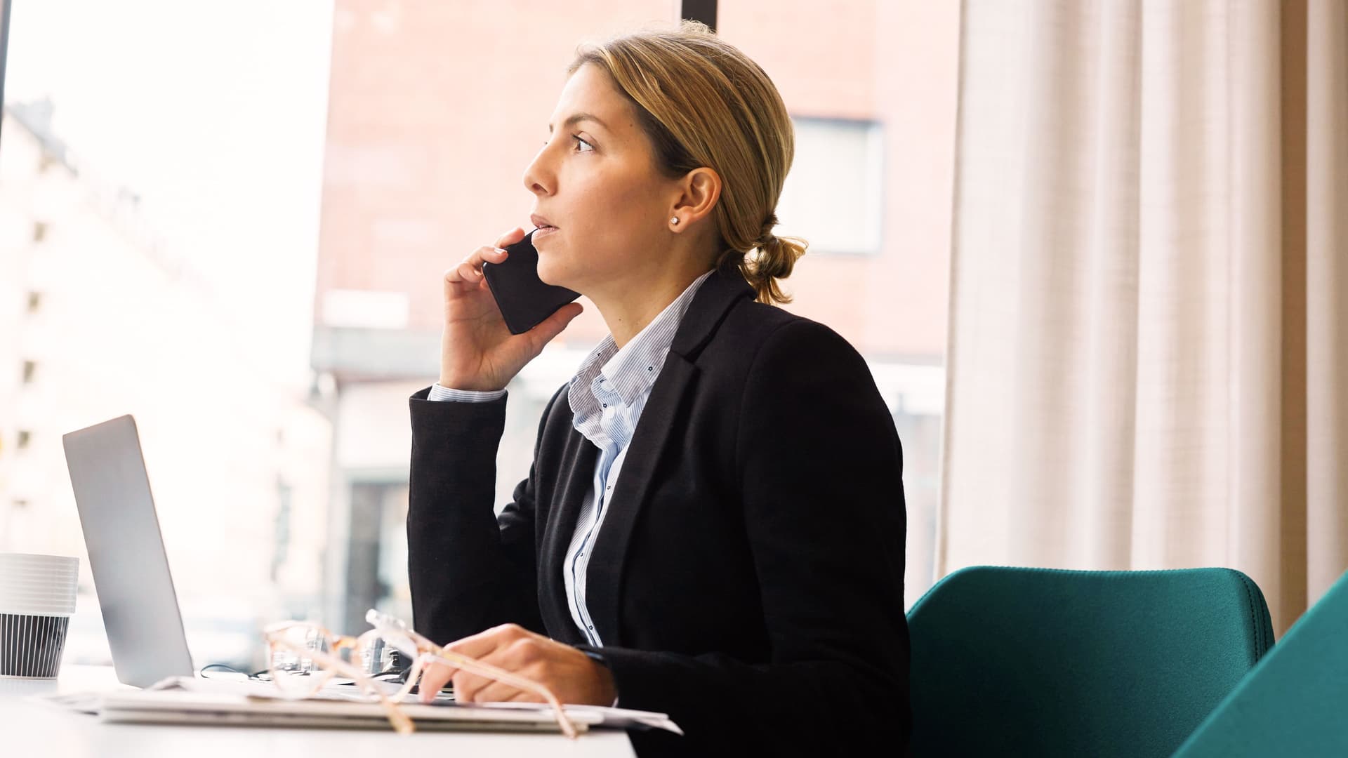 Selbstbewusste Geschäftsfrau im Gespräch am Smartphone im Büro