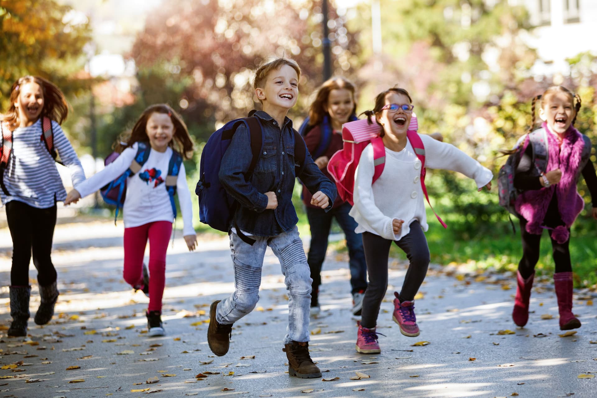 Schulkinder rennen auf den Weg zur Schule