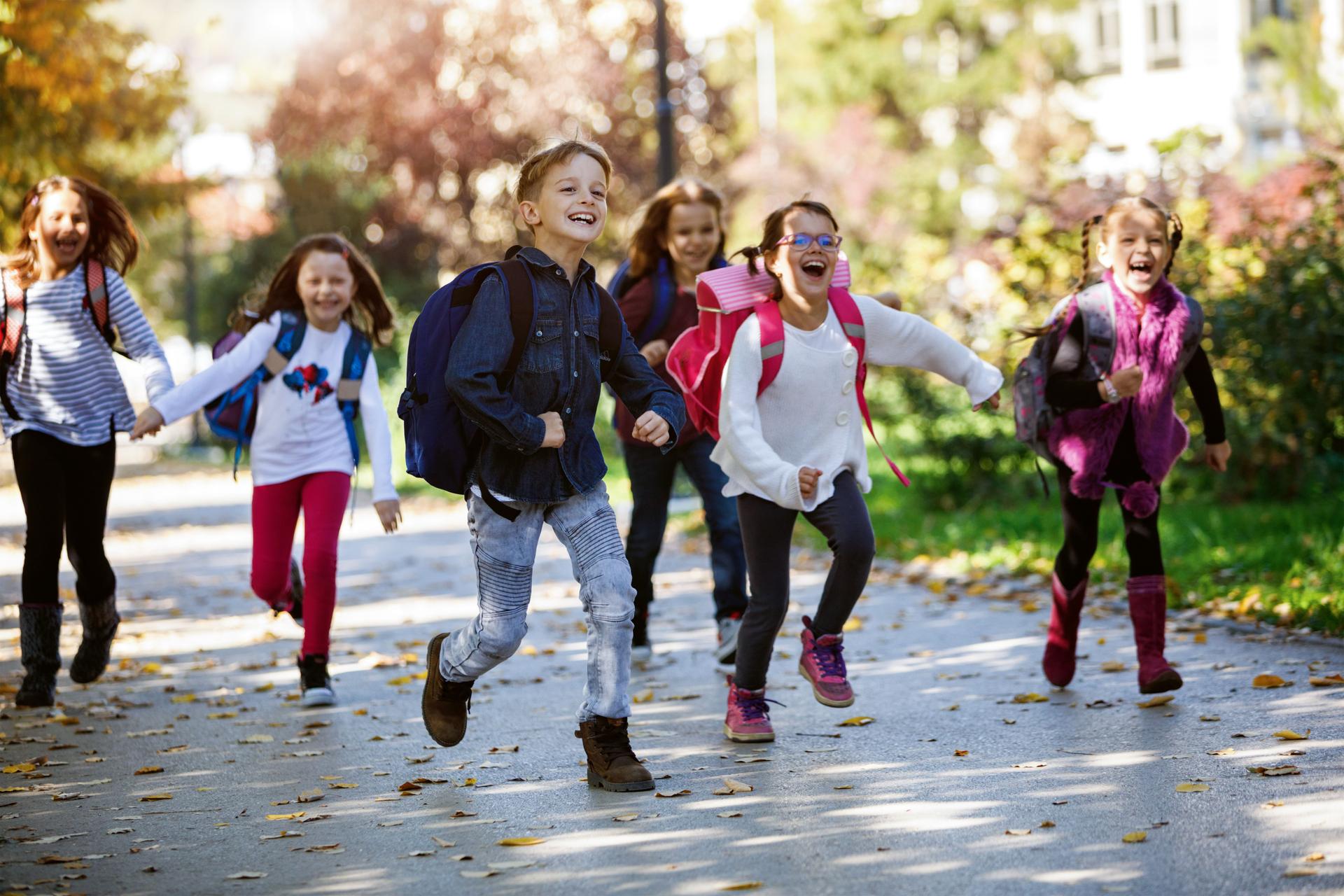 Schulkinder rennen auf den Weg zur Schule