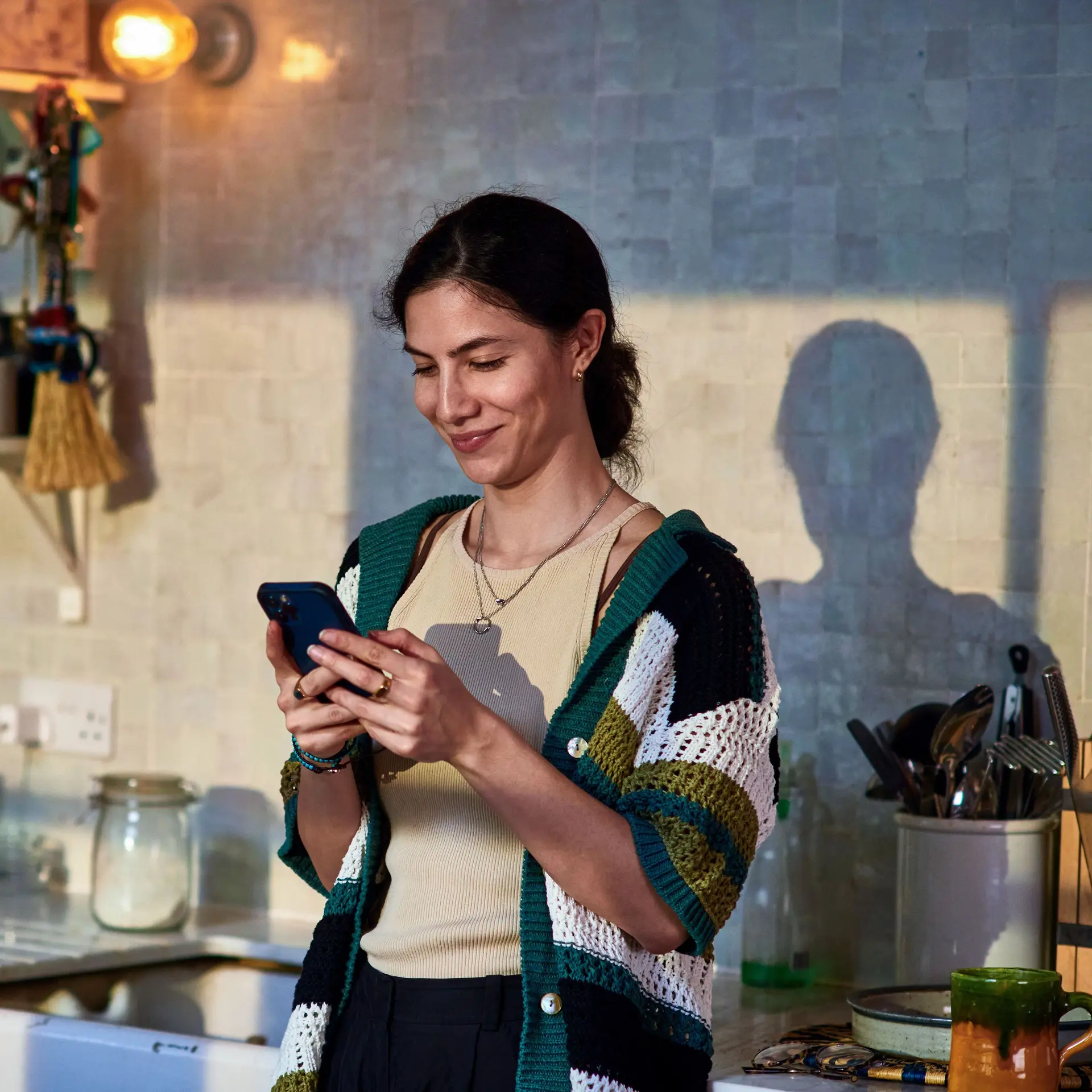 Lächelnde Frau mittleren Alters nutzt soziale Medien auf Smartphone