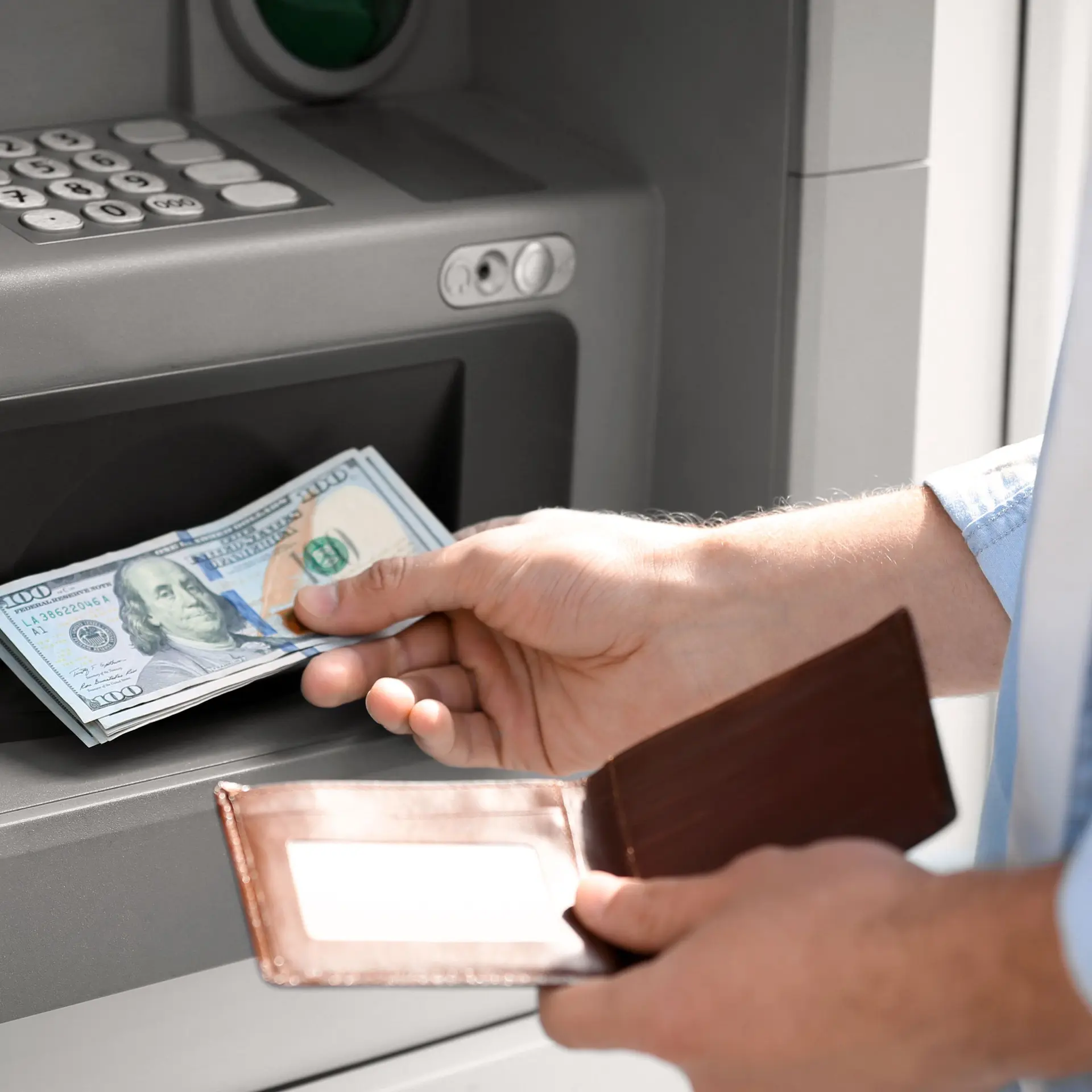 Ein Mann hebt Geld am Bankautomaten ab.