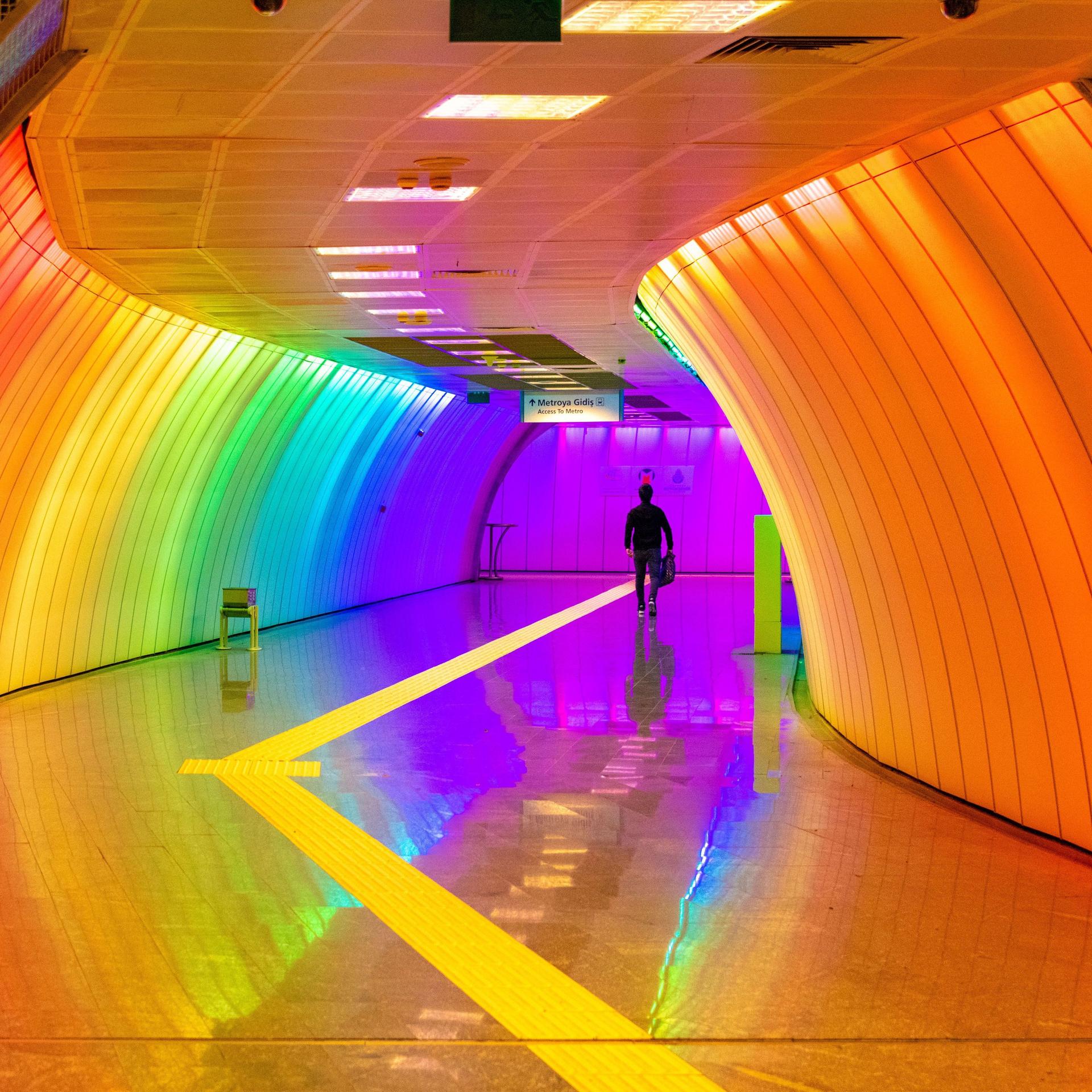 Ein regenbogen-farben beleuchteter Tunnel zur U-Bahn in Istanbul.