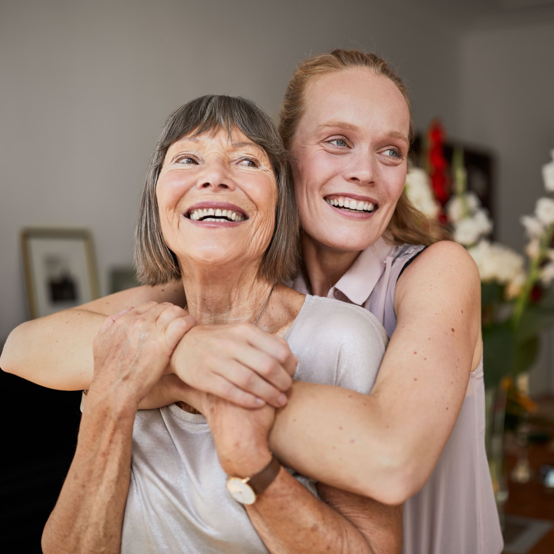 Mutter und Tochter umarmen sich liebevoll in einer Wohnung