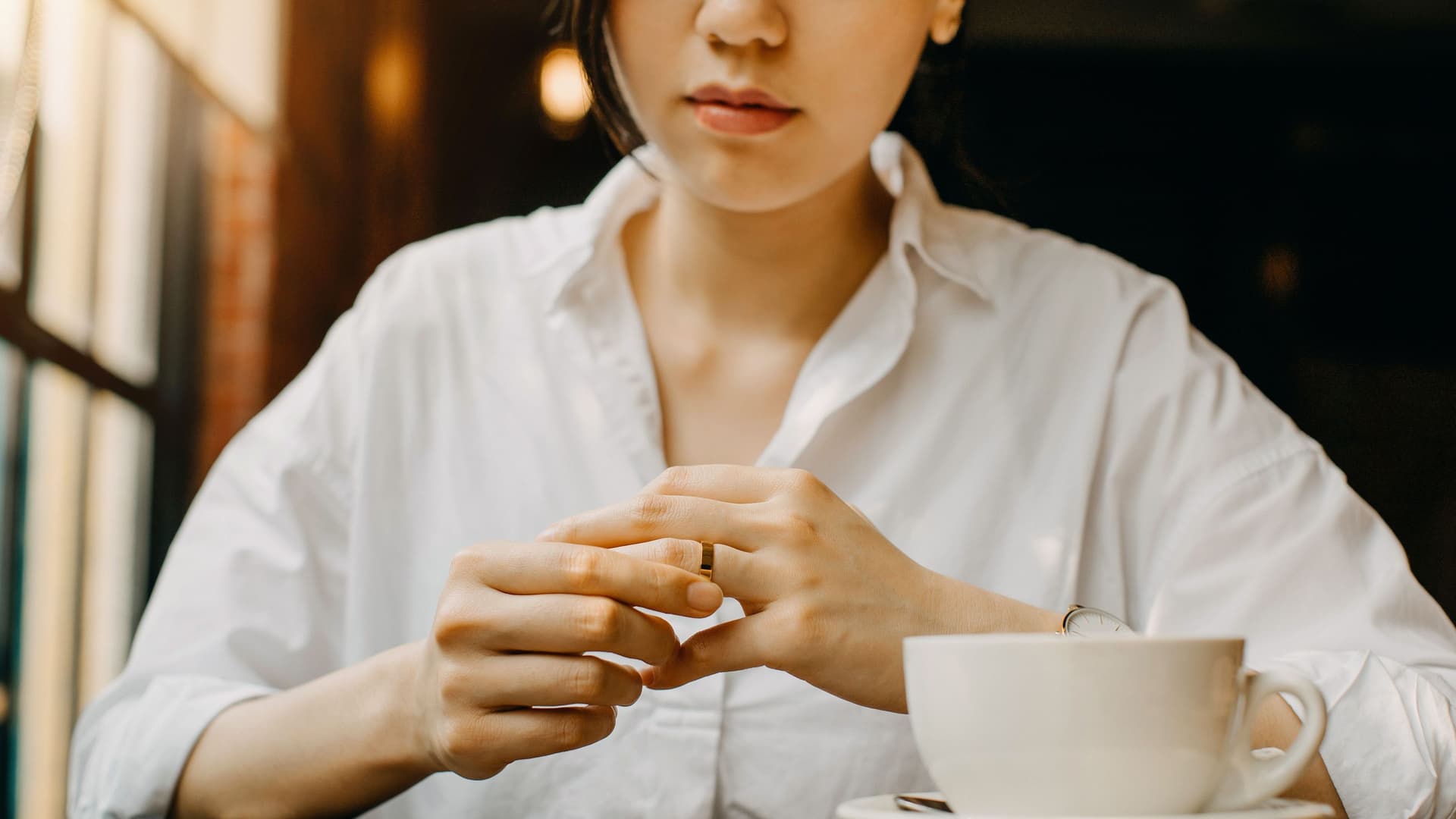 Nahaufnahme der Hände einer Frau, die ihren Ehering berührt