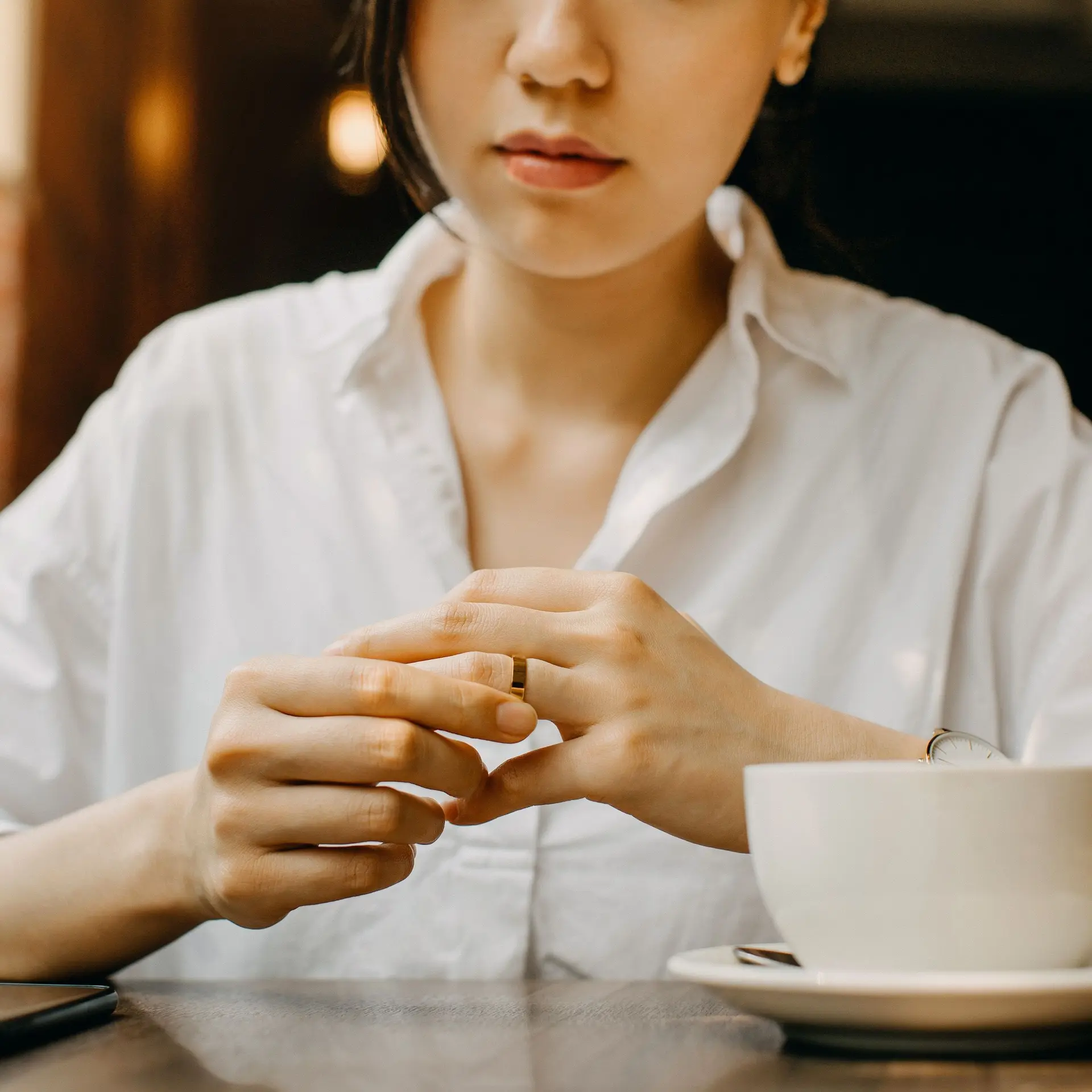 Nahaufnahme der Hände einer Frau, die ihren Ehering berührt