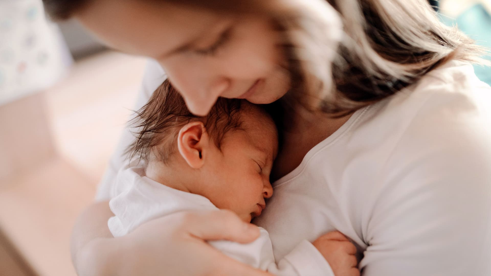 Nahaufnahme einer Mutter, die ein neugeborenes Baby auf dem Arm hält