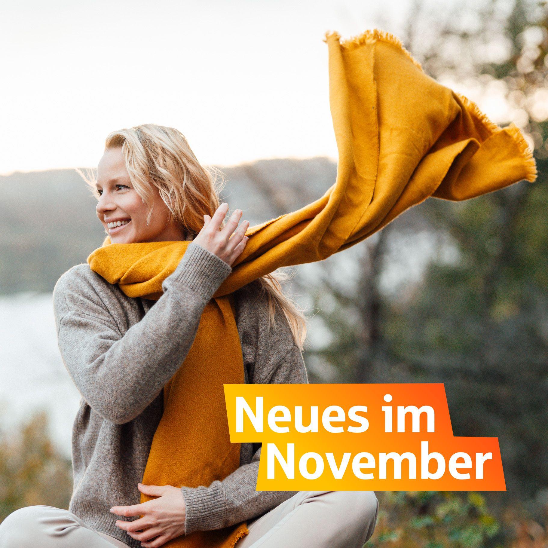 Eine lächende Frau wirft ihren gelben Schal über die Schulter. Unten rechts steht "Neues im November"