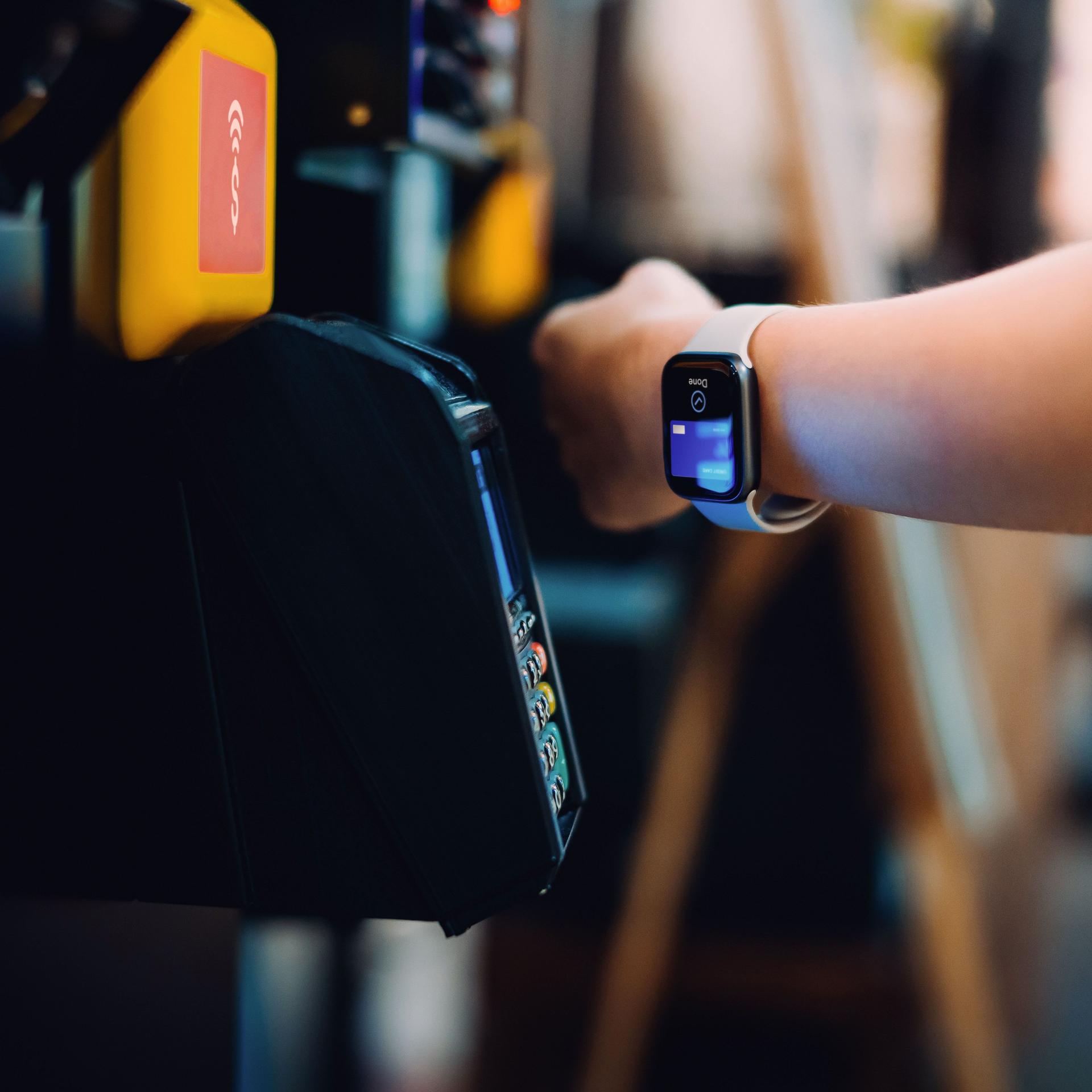 Nahaufnahme eines Handgelenks mit Smartwatch, die zum Bezahlen verwendet wird.