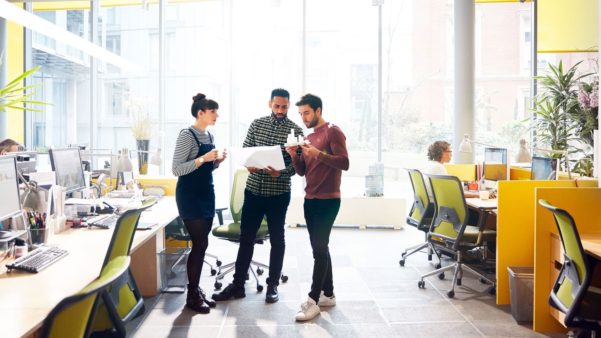 Personen stehen im Büro zusammen und unterhalten sich.