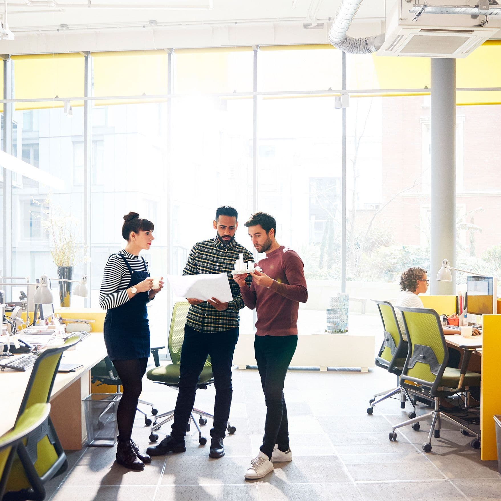 Personen stehen im Büro zusammen und unterhalten sich.