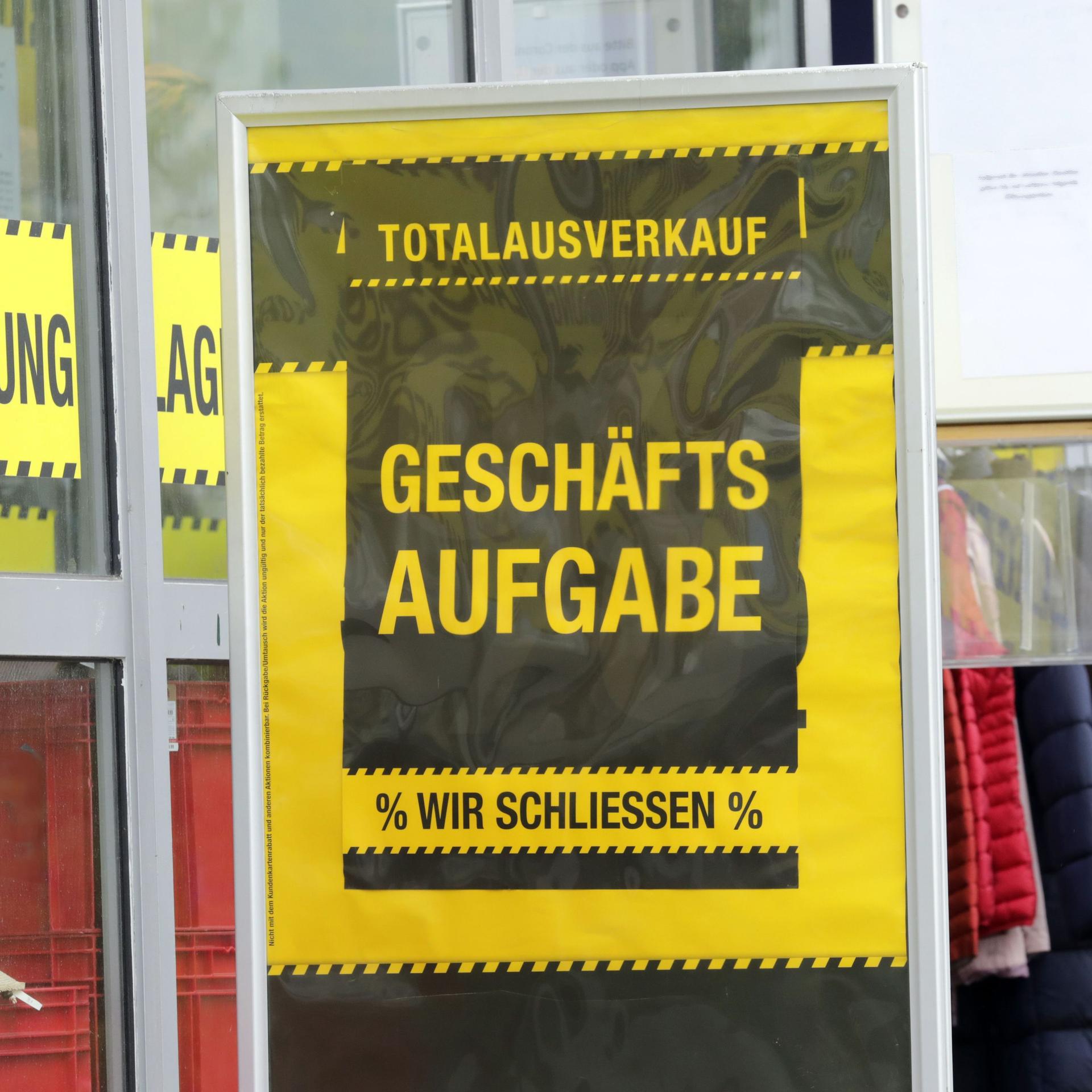 Plakat vor einem Laden mit der Aufschrift "Räumungsverkauf wegen Geschäftsaufgabe"