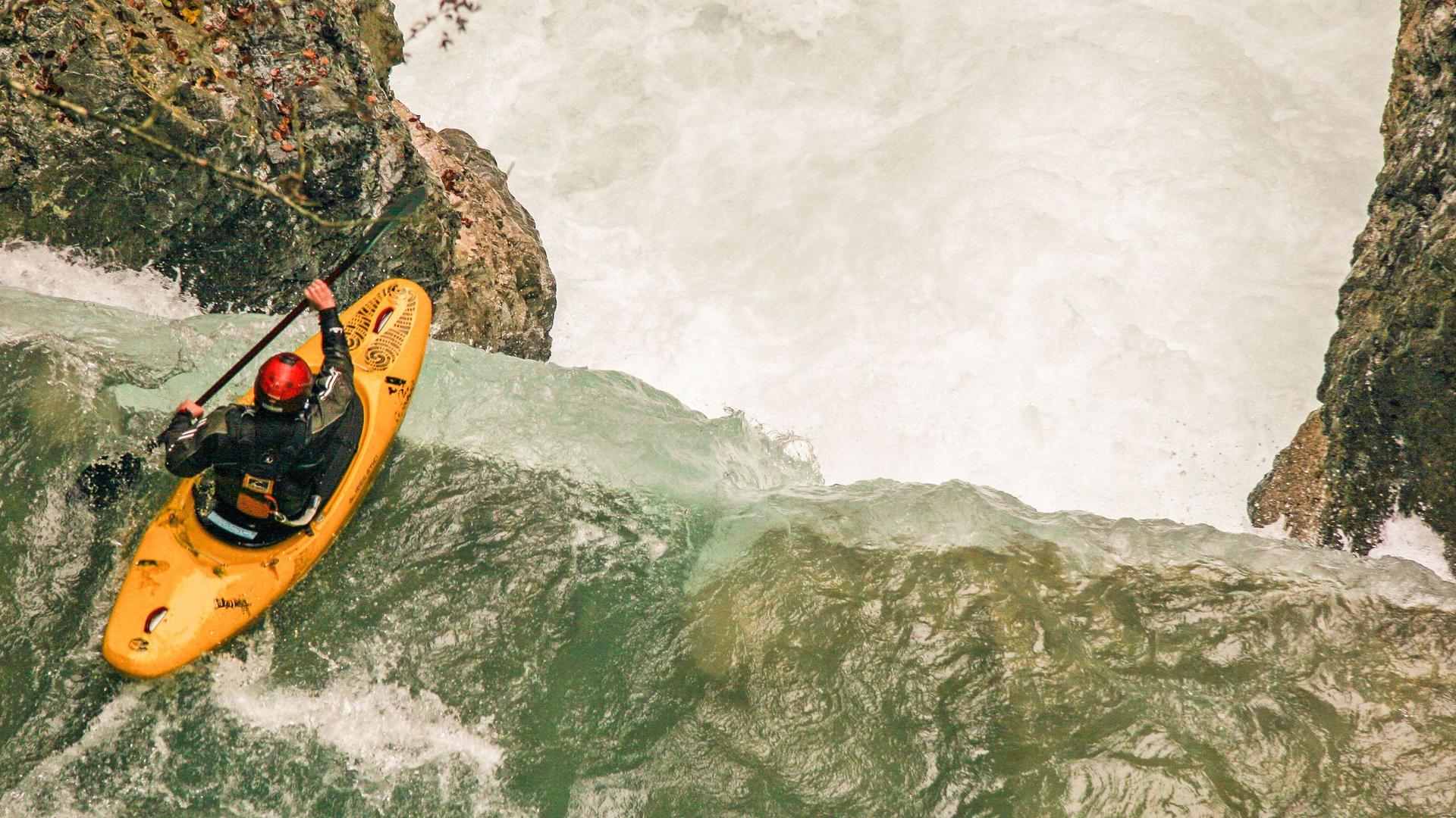 Ein Extremsportler mit Kajak an einem Wasserfall in der Rißbachklamm in Oberbayern.