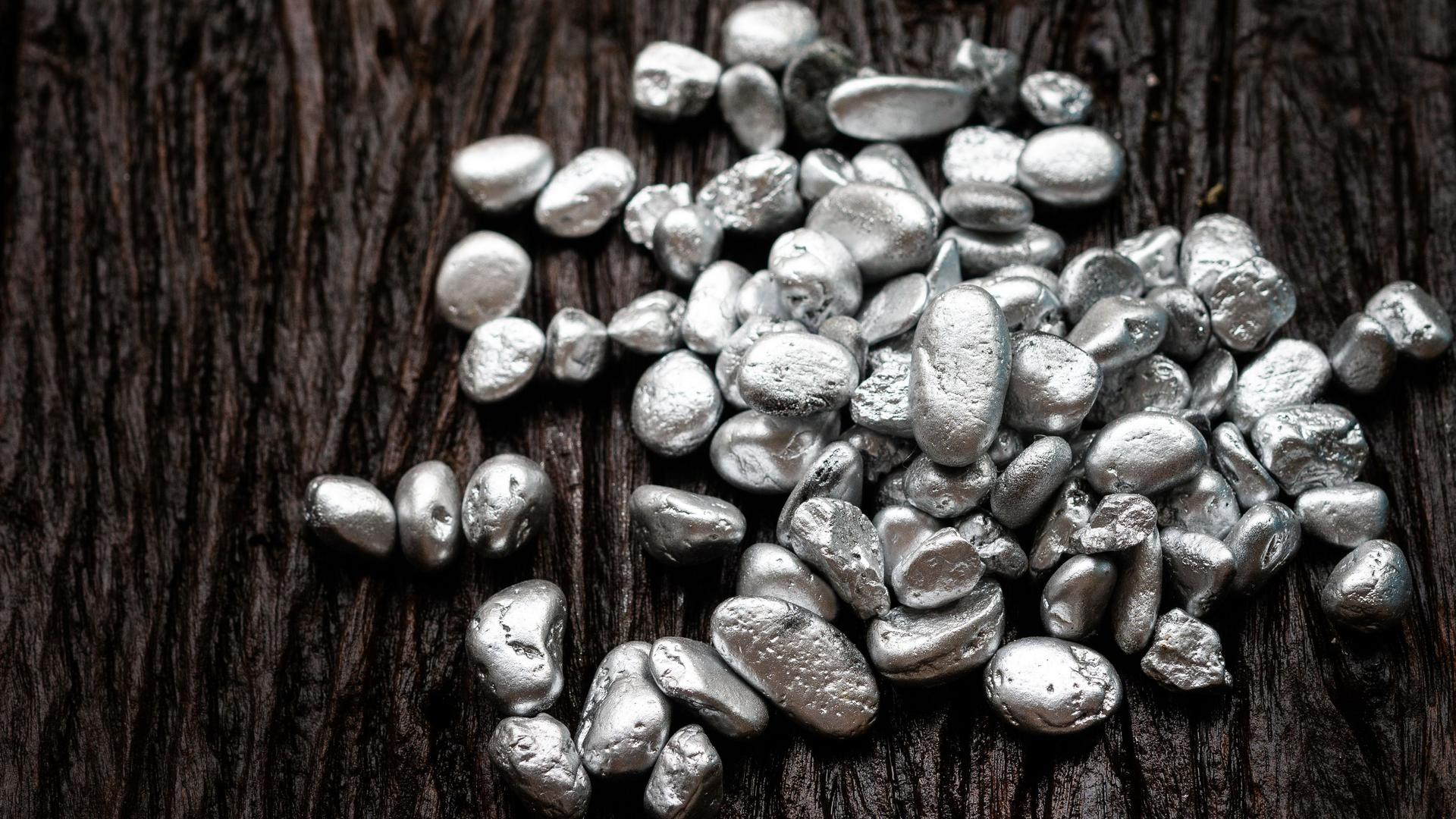 Klümpchen aus Silber- oder Platinerz auf einen alten Holzboden.