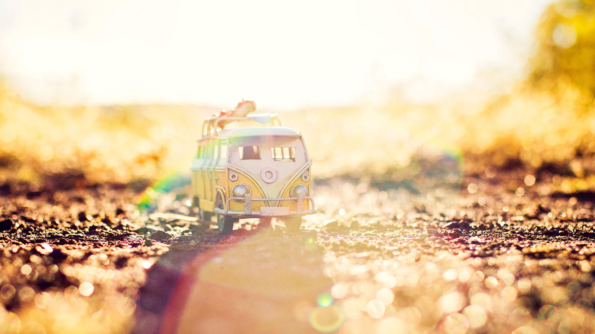 Ein Miniatur VW-Bus steht auf der Erde im strahlenden Sonnenschein.