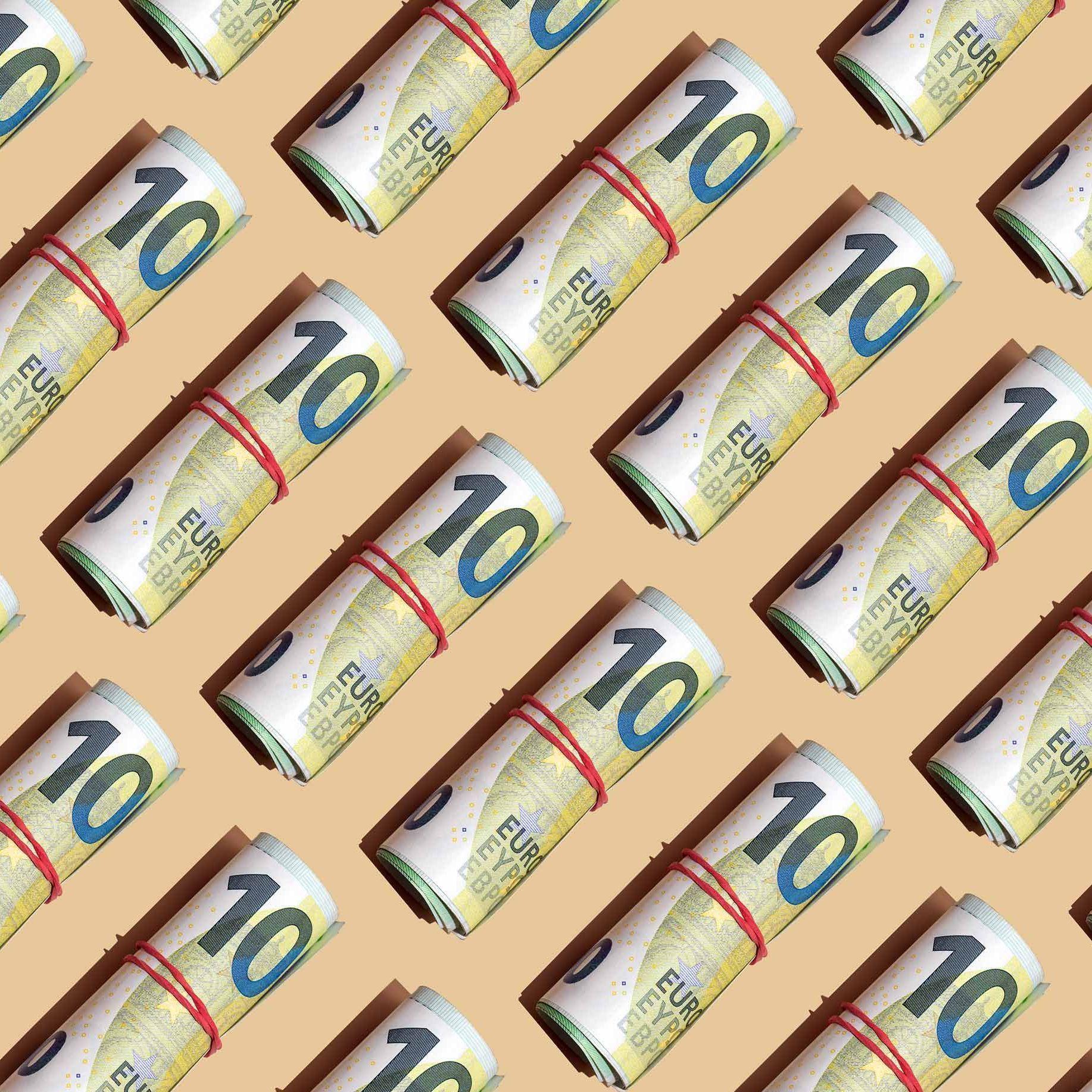 Ein grafisches Bild mit vielen 100 Euro Banknoten mit roten Gummibändern zu Geldbündeln zusammengerollt. Sie liegen aneinandergereiht mit gleichen Abständen auf einem gelben Untergrund.