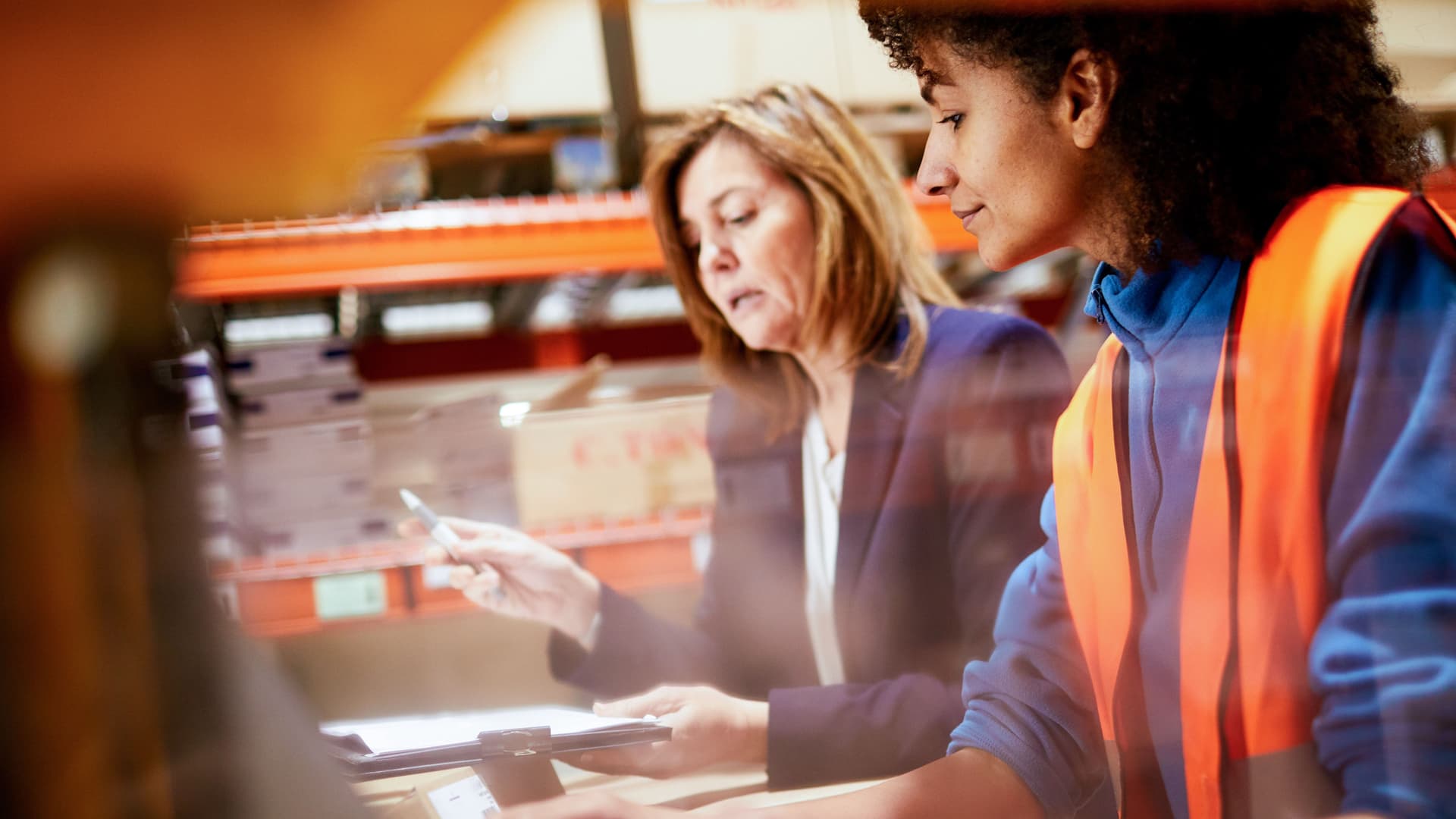 Zwei Mitarbeiterinnen geben in einem Lager Daten in den Computer ein.