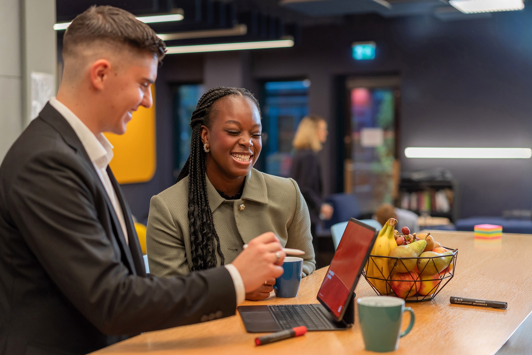 Mitarbeitende am Stehtisch unterhalten sich fröhlich
