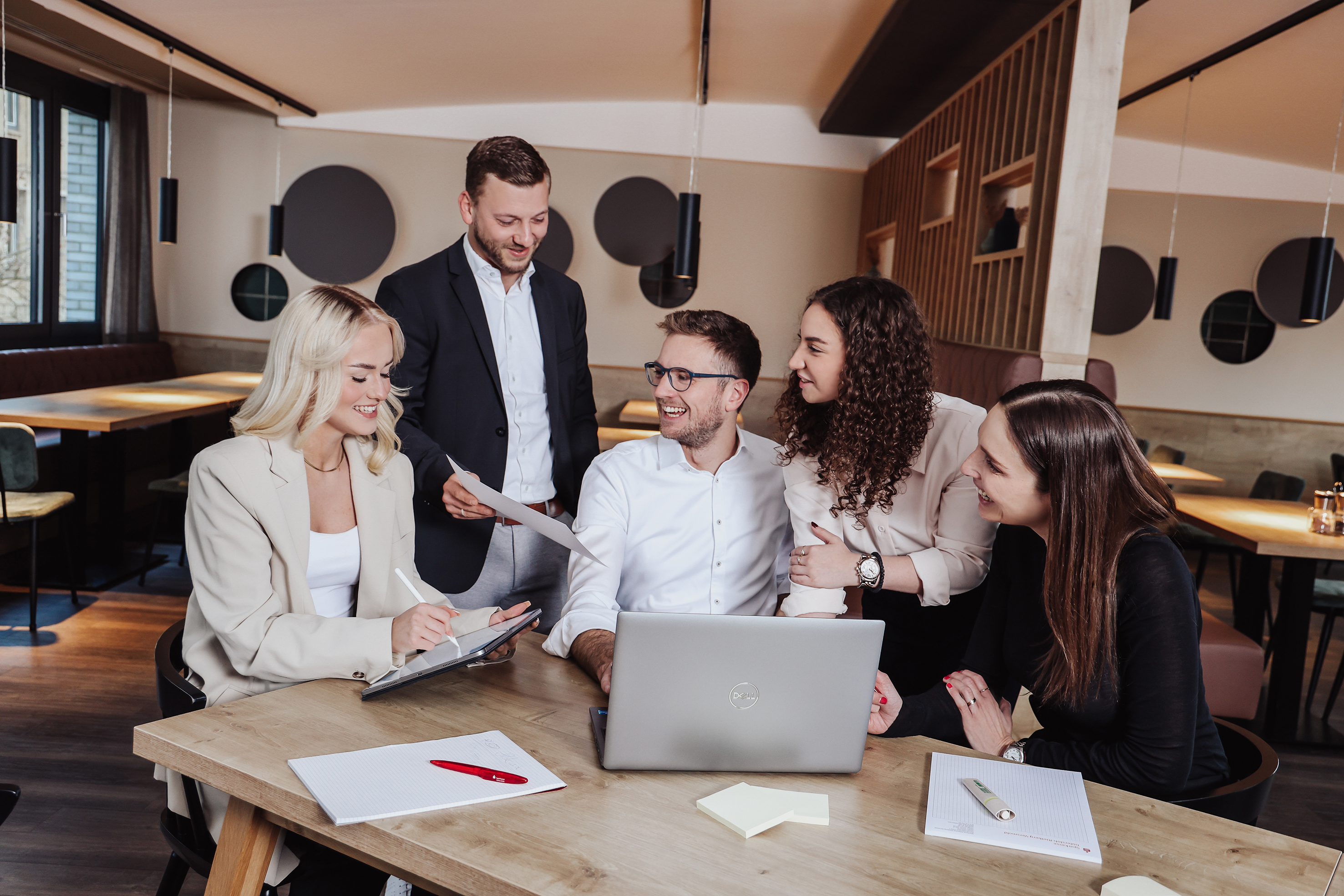 Fünf Mitarbeiter arbeiten im Team an einem Projekt