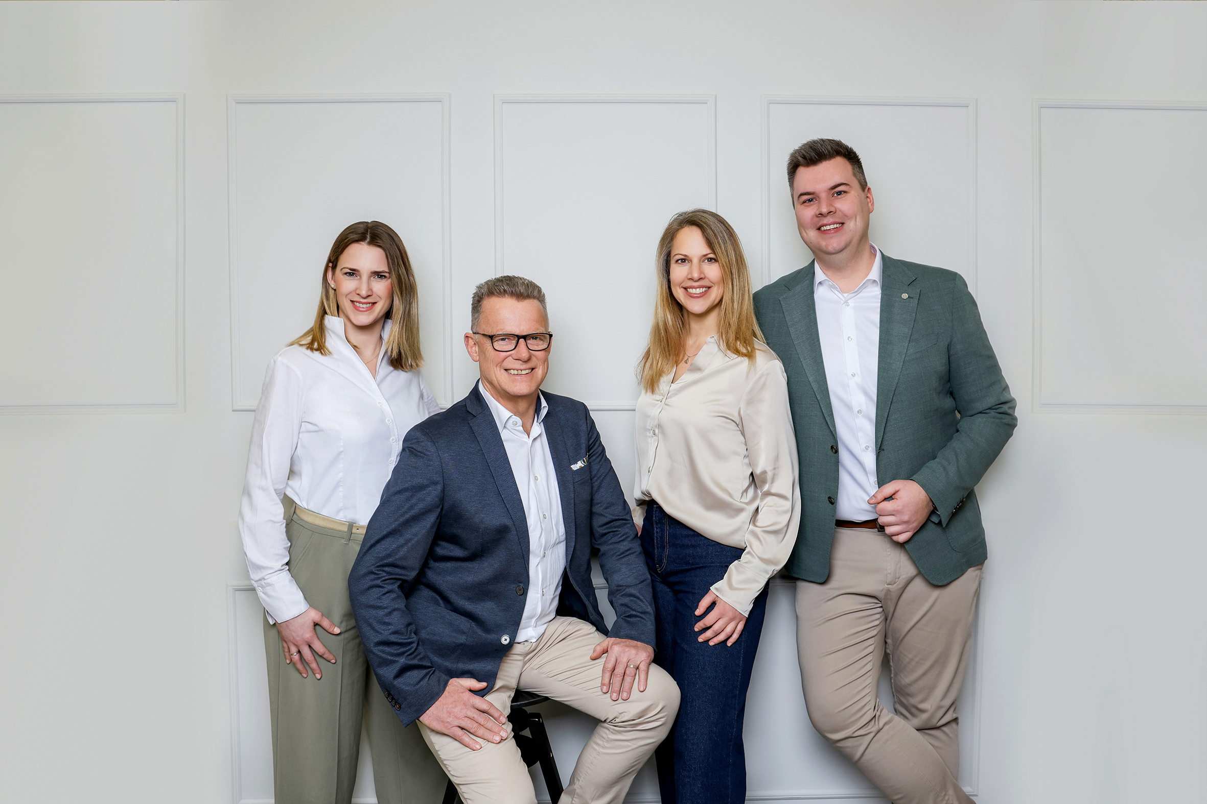 Team steht vor der Wand - zwei Frauen und zwei Männer 
