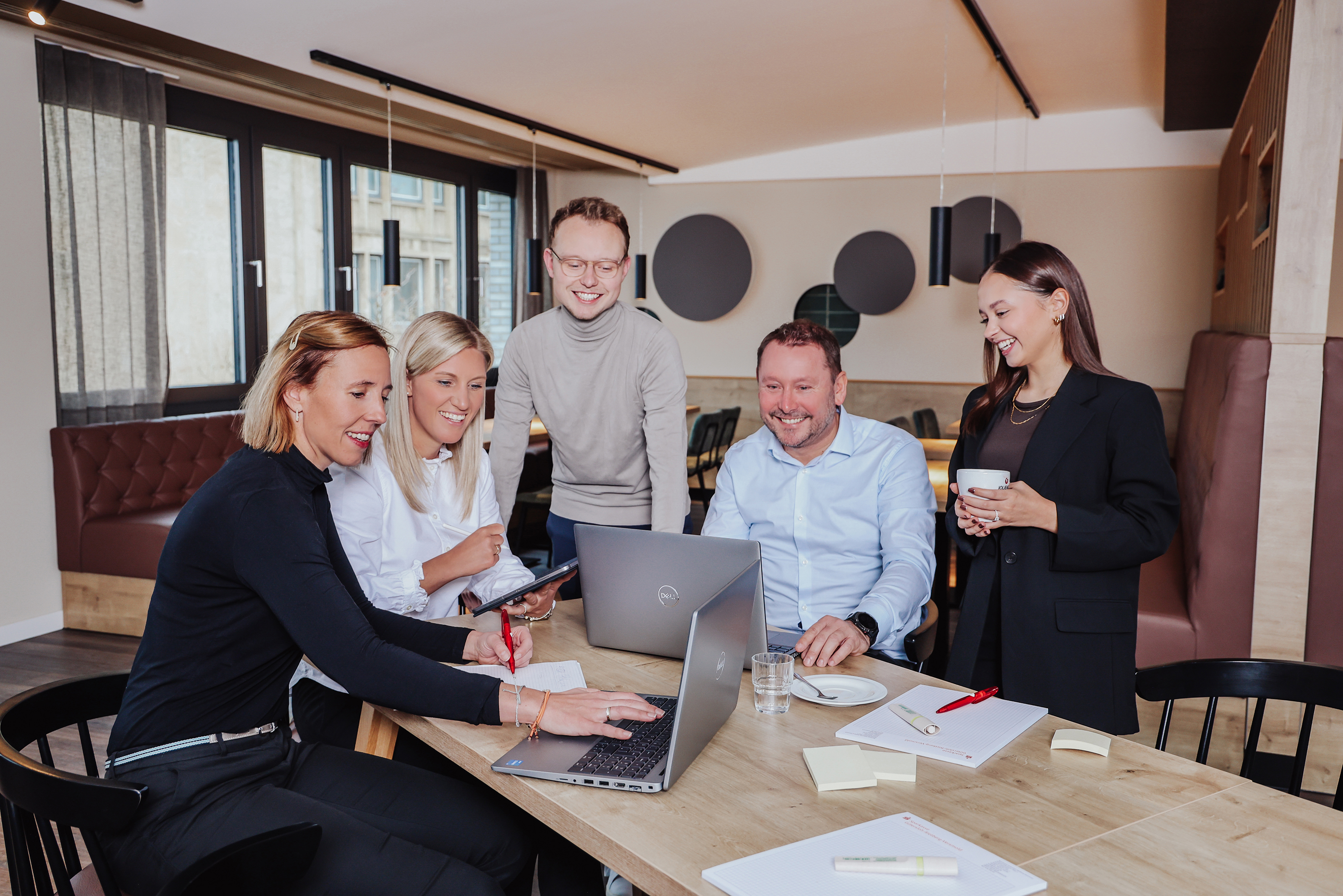 Gruppe von Kollegen arbeiten gemeinsam an einem Projekt und sitzen am Tisch