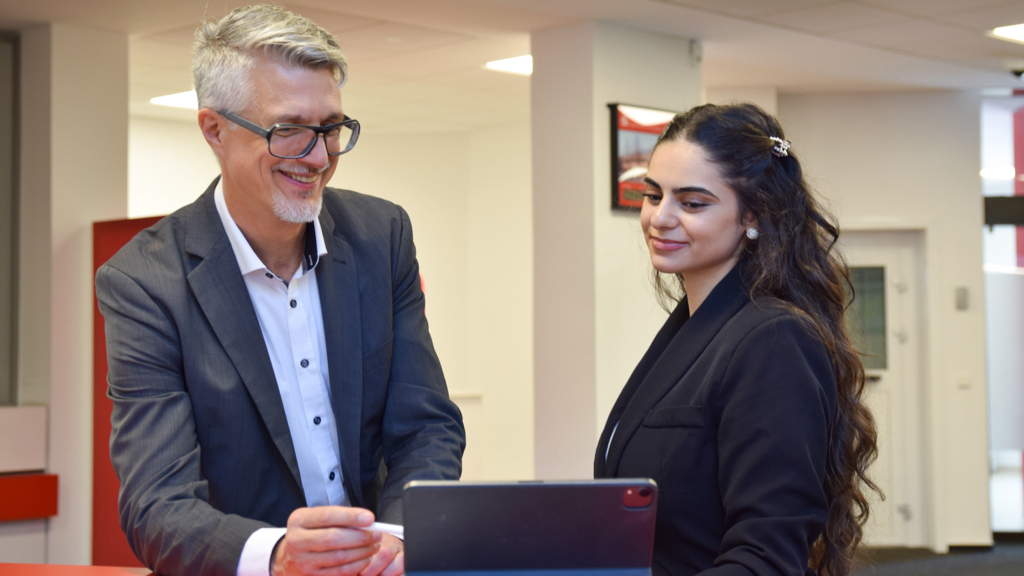 Zwei Kollegen schauen aufs Tablet