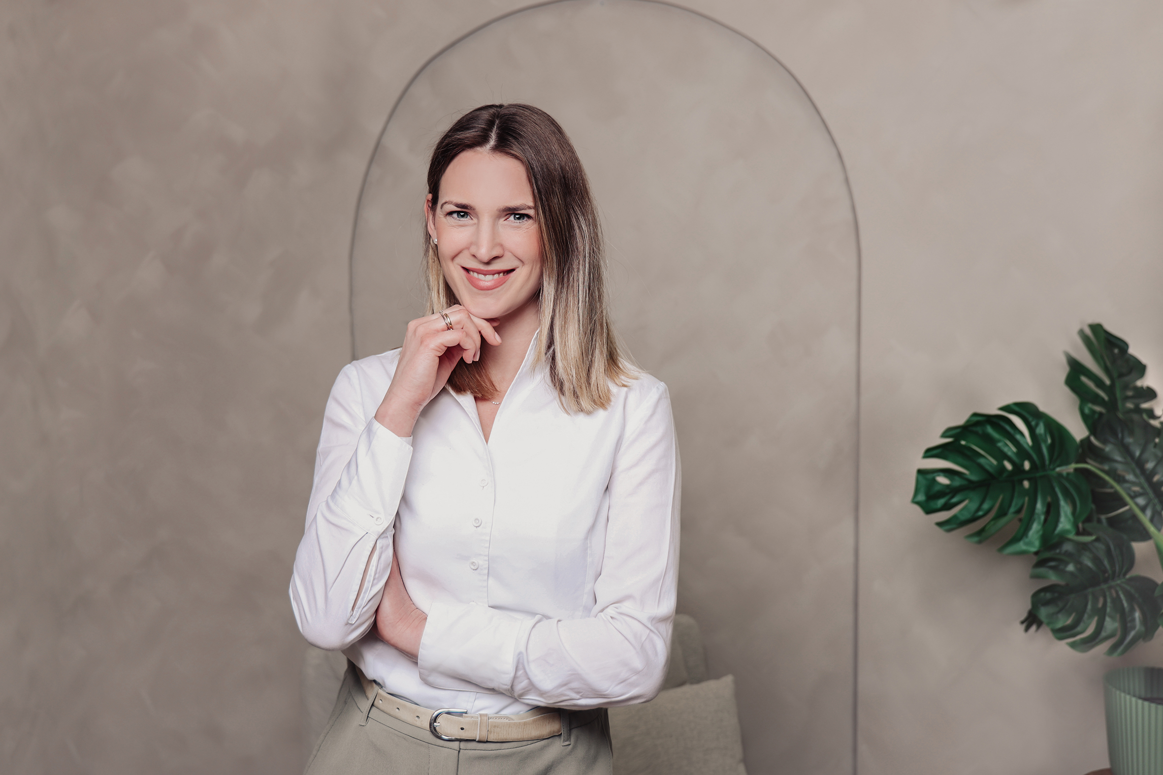 Frau im Portrait steht vor einer Wand