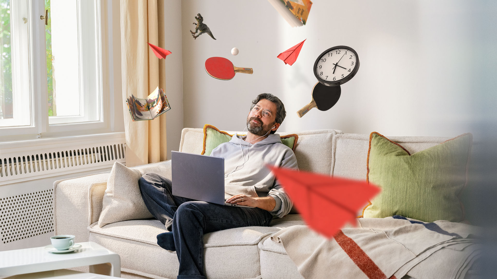 Mann sitzt auf dem Sofa und die Lebenswelten fliegen durch die Luft.